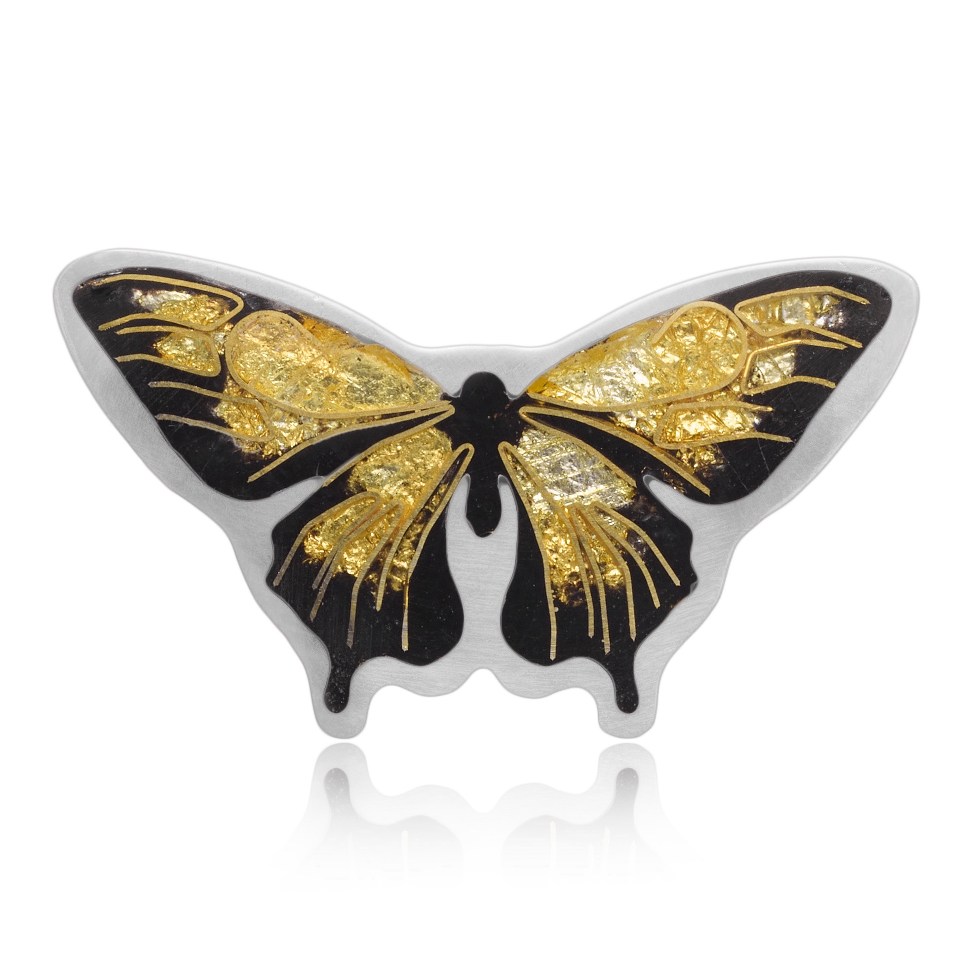 detail of a small black and gold butterfly necklace. It's made with the cloisonne technique and has tiny gold wires. The butterfly is mostly gold, with a black border around the edges, and set into a silver frame.